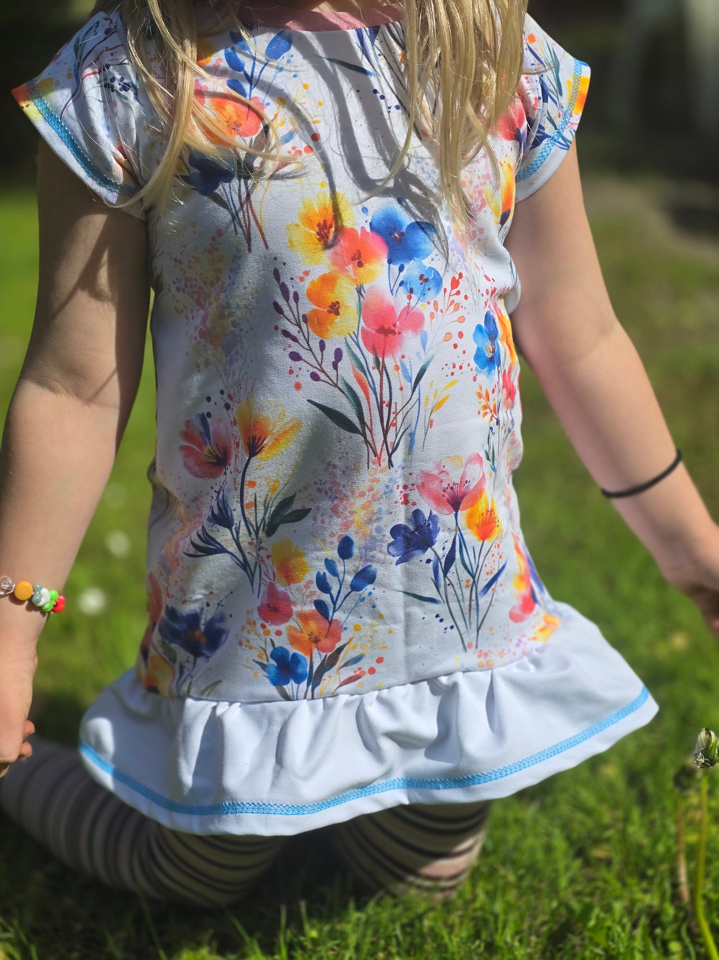 Nahaufnahme des Watercolor Flowers Stoffes mit fein gemalten Blüten und Farbverläufen auf strahlend weißem Untergrund.