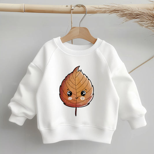 „Kinder-Sweater mit mittig platziertem braunen Buchenblatt-Bügelbild; zeigt Größe und Position des Motivs deutlich auf dem Kleidungsstück.“