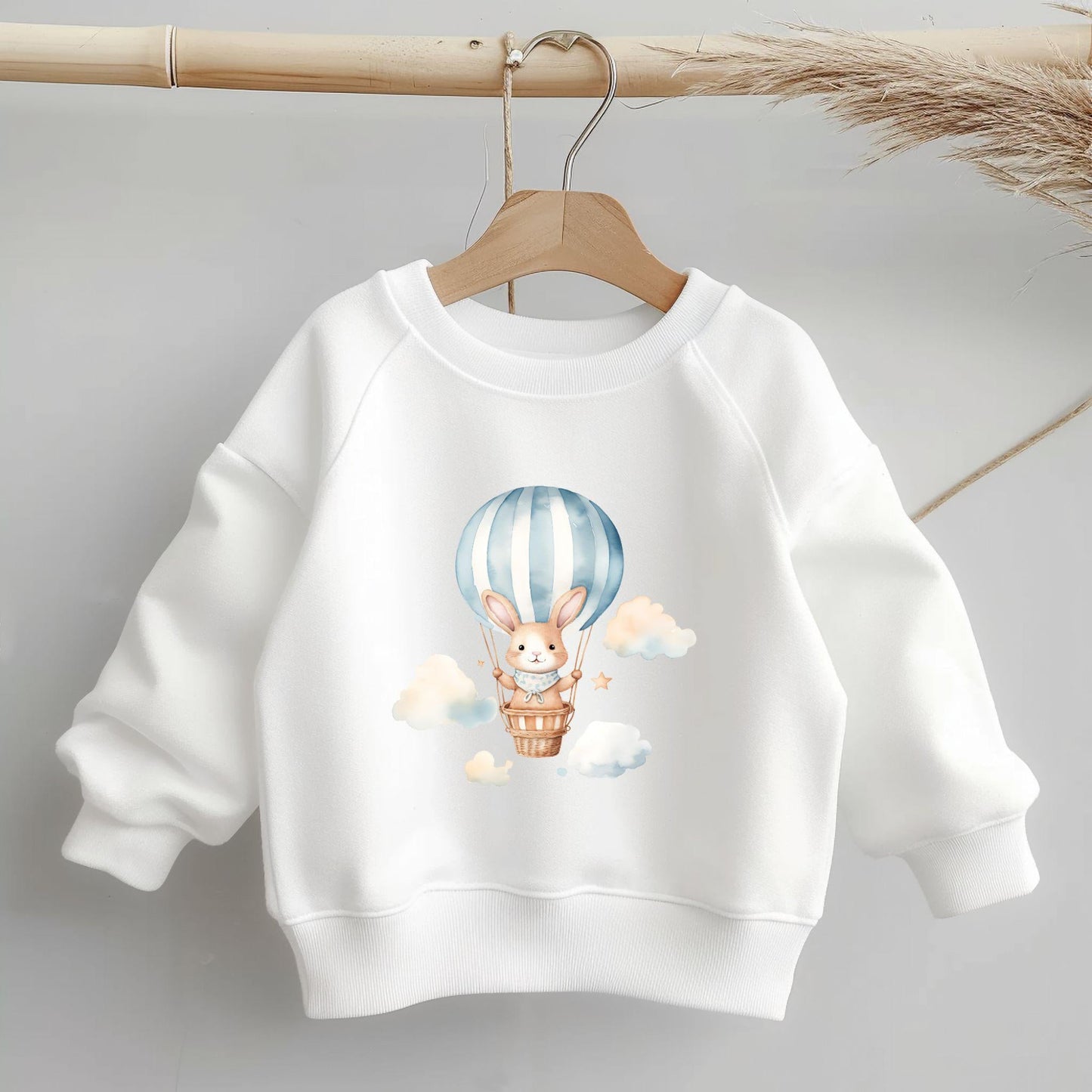 Bügelbild Ballontier mit süßem Hasen im Heißluftballon auf weißem Kinderpullover.