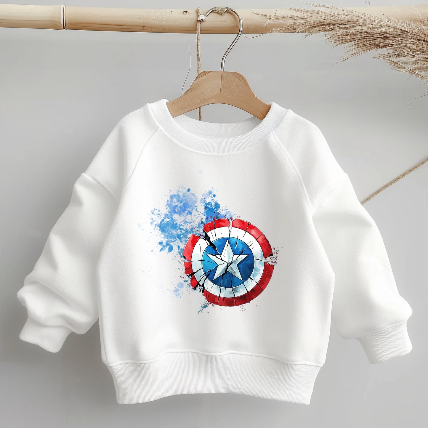 Kinderpullover mit rot-blauem Schild-Bügelbild auf weißem Hintergrund.