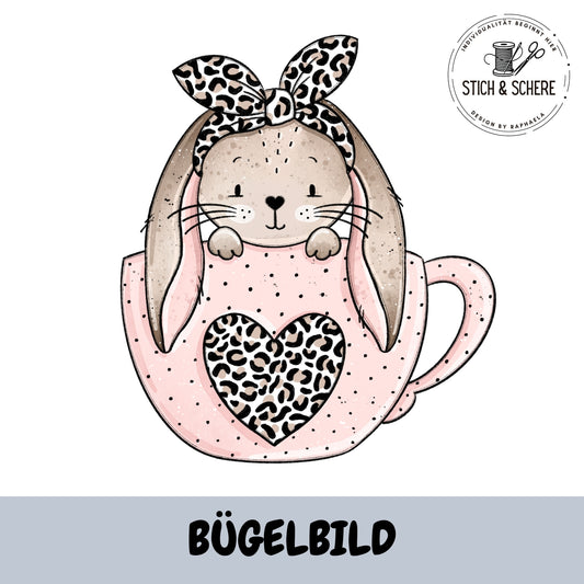 BĂŒgelbild Schlappohrlein ohne Brille â HĂ€schen mit Leoparden-Haarband in rosa Tasse mit Leo-Herz â Katzengold-Designs