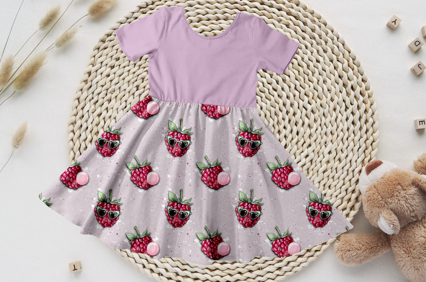 Kinderkleid mit lavendelfarbenem Bio-Jersey-Oberteil und Himbeer-Rock mit Brillen-Motiven.