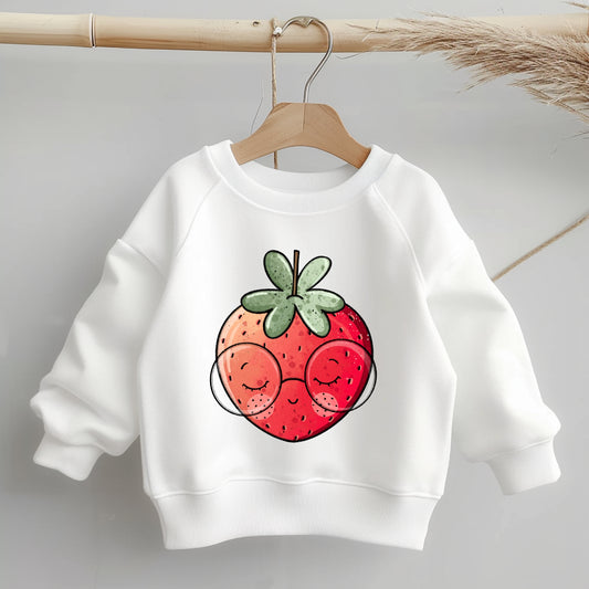 „Mockup eines einfarbigen Kinder-Sweaters: mittig auf der Brust das Bügelbild einer lächelnden Erdbeere mit runder Brille; zeigt Größe und Platzierung des Motivs.“