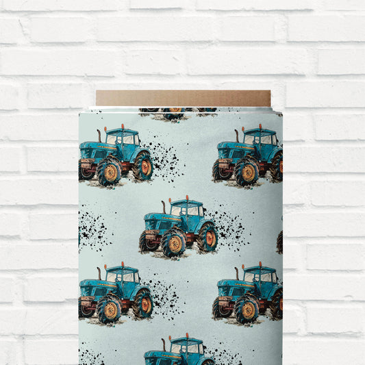 Jersey- und French Terry-Stoff mit rustikalem Traktor-Design und Schlammspritzern – ideal für selbstgenähte Hoodies, Shirts, Pumphosen und mehr.