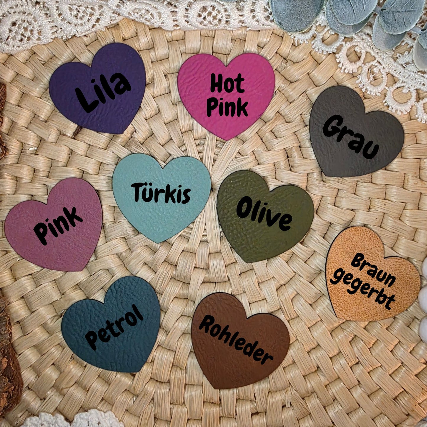 Farbübersicht der verfügbaren Kunstlederlabel – Herzformen in Lila, Hot Pink, Grau, Pink, Türkis, Olive, Petrol, Rohleder und Braun gegerbt auf Bastuntergrund.