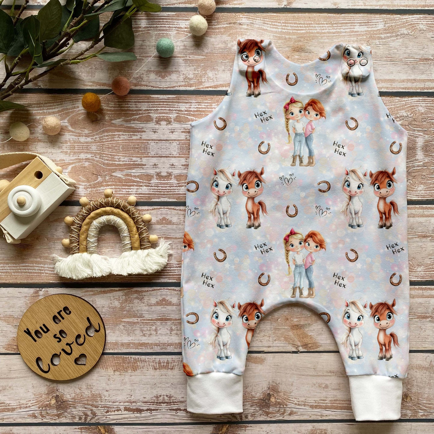 Babystrampler aus „Mimi & Mina“-Stoff mit liebevollen Pferde-Details.