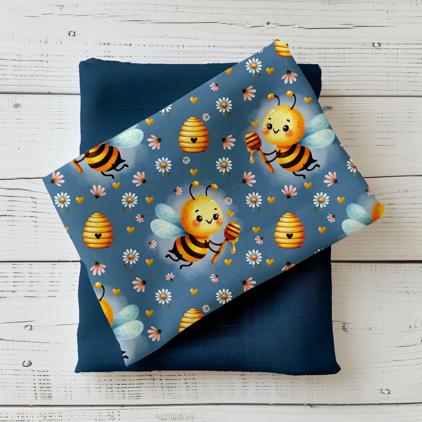 Mockup: Stoff „Bee Happy“ – niedliche Bienen mit Honiglöffel, Bienenkörbe, Gänseblümchen & goldene Herzen auf taubenblauem Hintergrund; Stoffkachel diagonal auf passendem Uni als Kombistoff.
