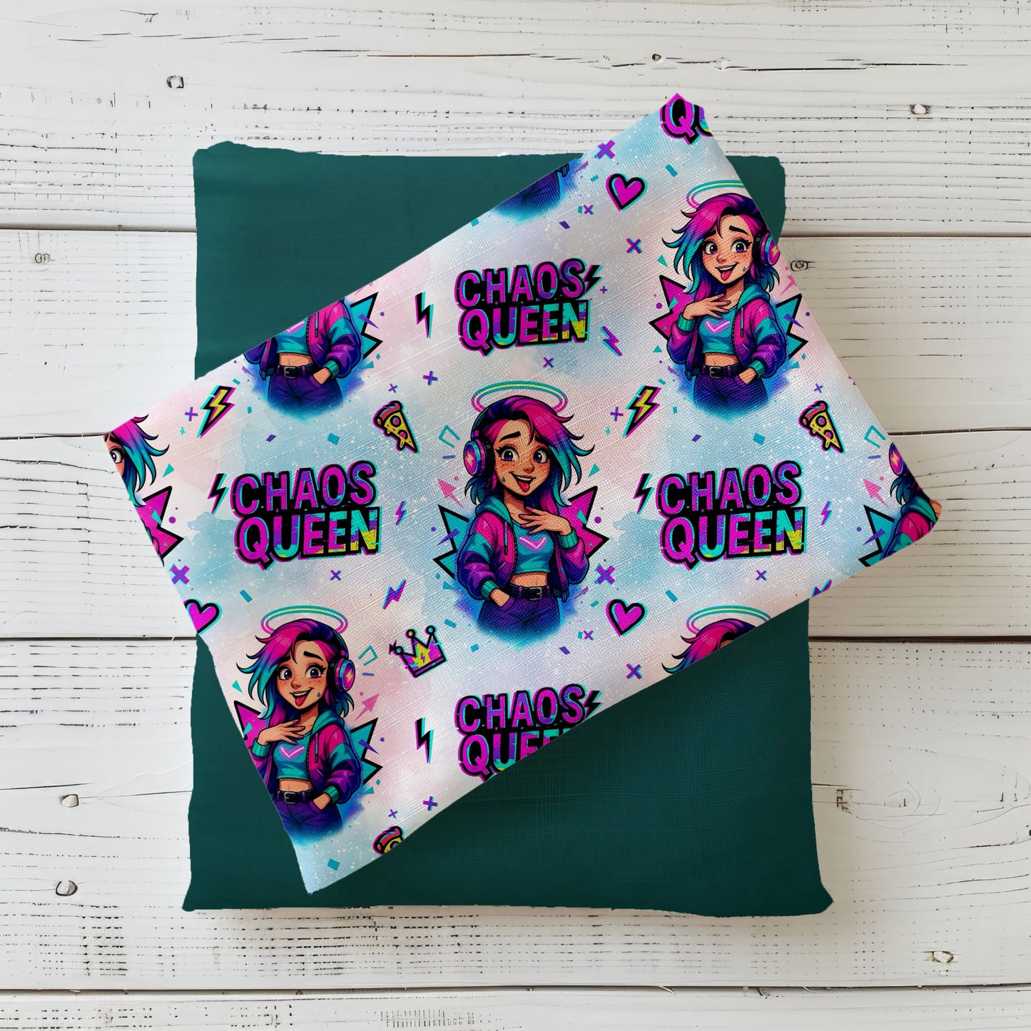 Nahtloses Stoffdesign „Chaos Queen“ mit bunter Comic‑Figur: junge Frau mit pink‑türkisfarbenem Haar, Kopfhörern, lila Bomberjacke, vor buntem Hintergrund mit Herzen, Blitzen, Pizza‑Stück und der Aufschrift „Chaos Queen“ in Neonfarben.