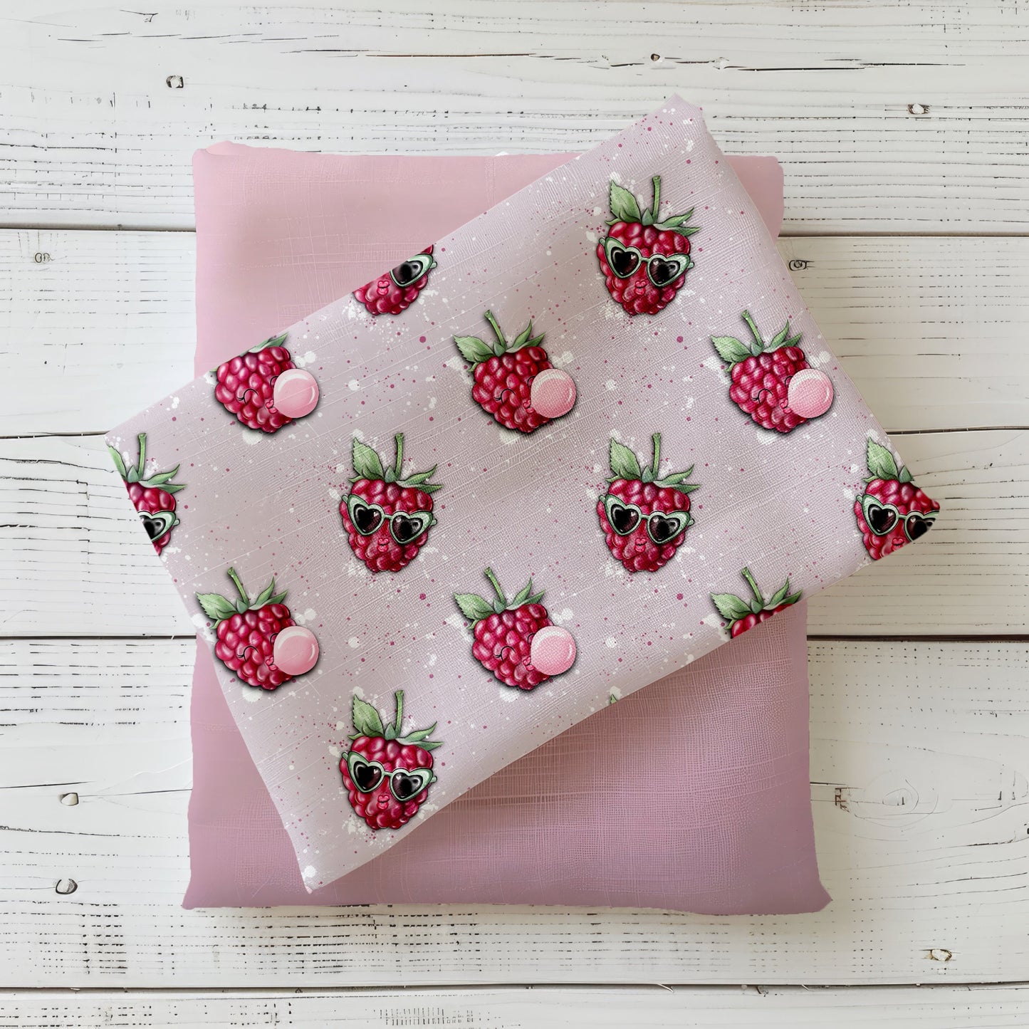 Mockup: Stoff „Freche Himbeere“ – Himbeeren mit Herz-Sonnenbrillen und Kaugummi-Bläschen auf zartrosa Sprenkel-Hintergrund; Stoffkachel diagonal auf passendem Uni in Rosa/Mauve als Kombi.
