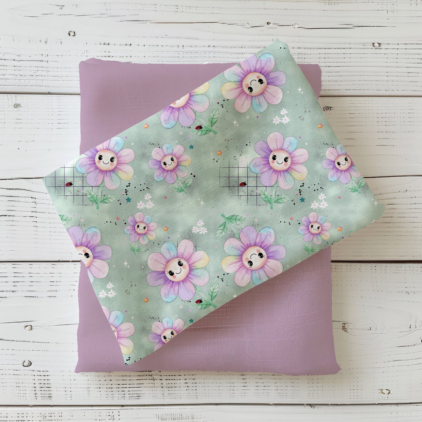 Mockup: Stoff „Fröhliche Blumen“ – pastellige, lächelnde Blumen mit Blättern, Sternen & Sprenkeln auf mintgrünem Grund; Stoffkachel diagonal auf passendem Uni als Kombi platziert.
