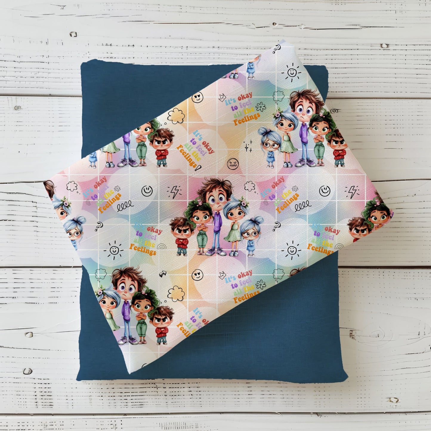 Niedlicher Kinderstoff als Meterware mit fünf verschiedenen Charakteren. In den zwischenräumen befinden sich Smileys und andere Symbole. Außerdem steht in den Zwischenräumen "It's okay o feel all this Feelings!". Der Hintergrund ist bunt in regenbogenfarben mit Farbverlauf und einem weißen Grid.