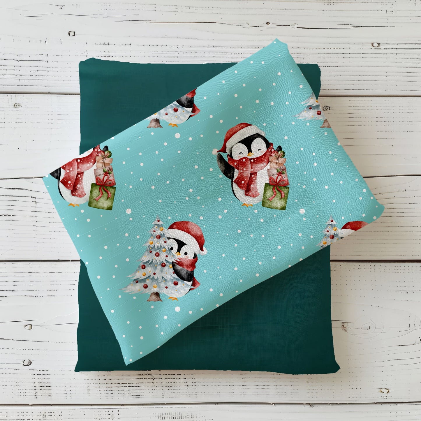 Weihnachtsstoff „Süße Pinguine“ mit niedlichem Pinguin, Geschenken und geschmücktem Tannenbaum auf türkisem Hintergrund.