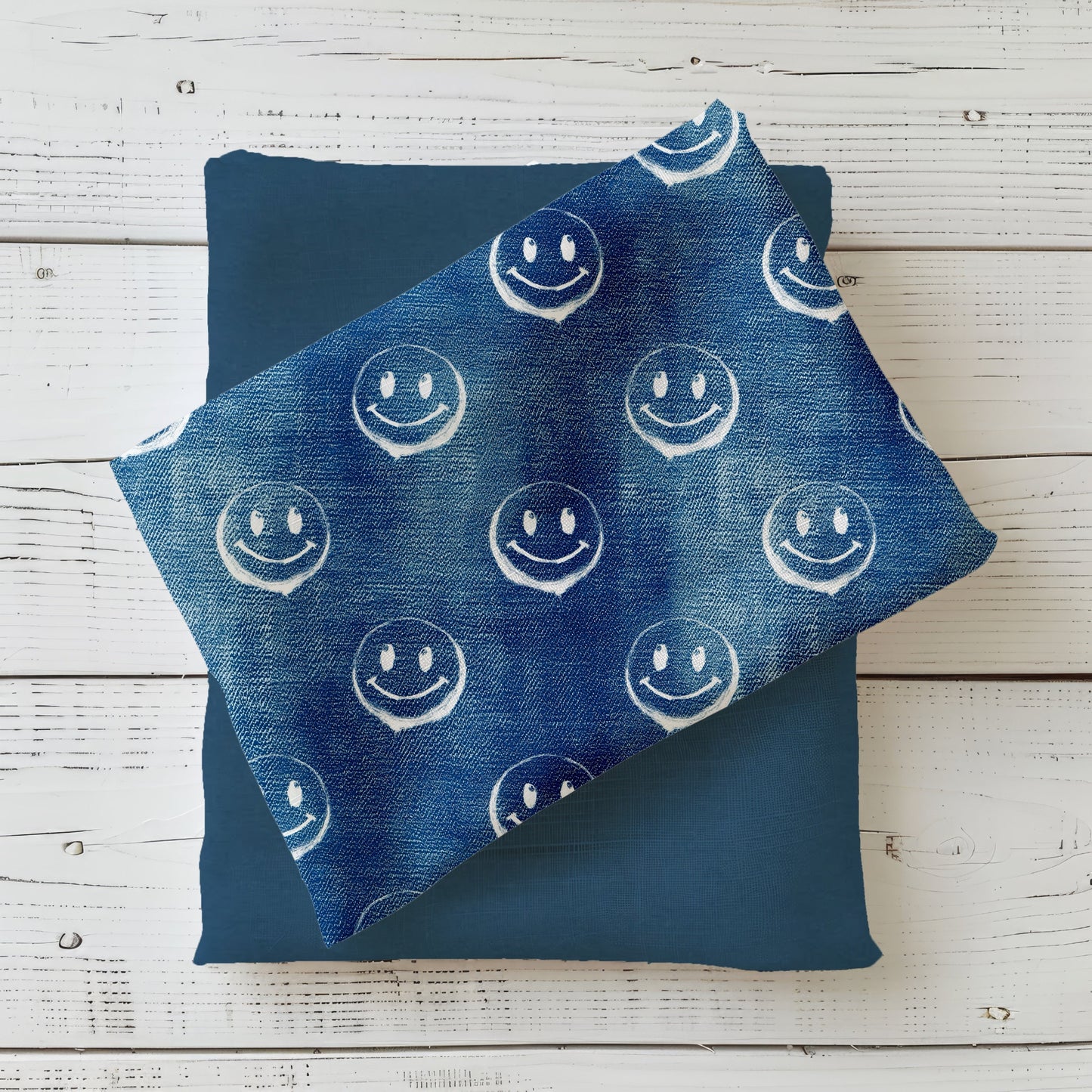 Gefalteter Stoff des Designs „Smiley – Denim blau“ mit durchgehendem Smiley-Muster.