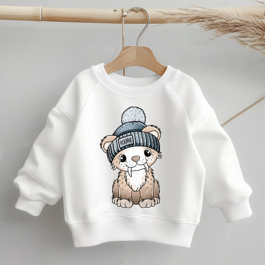 Freigestelltes Bügelbild „Säbi der Säbelzahntiger mit Mütze“ – klare Kontur, warme Naturtöne, blaue Mütze; ideal als Aufbügelmotiv für Kinder-Shirts, Hoodies, Mützen oder Taschen.