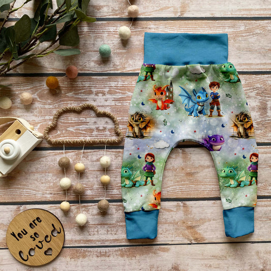 Handgemachte Pumphose „Die Drachenwächter – Azurblau“ mit Ritter- und Drachenmotiv auf French Terry, kombiniert mit azurblauen Bündchen.