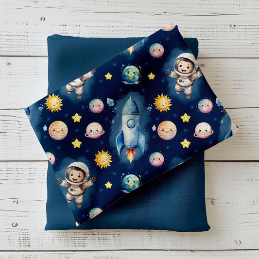 Hochwertiger Kinderstoff mit Astronauten, Raketen und Planeten auf dunklem Hintergrund – ideal für Baby- & Kinderkleidung.