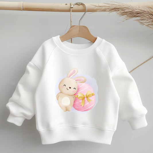 Bügelbild "Hase mit Schleifenosterei" auf weißem Kinderpullover – Oster-Motiv für DIY-Projekte.