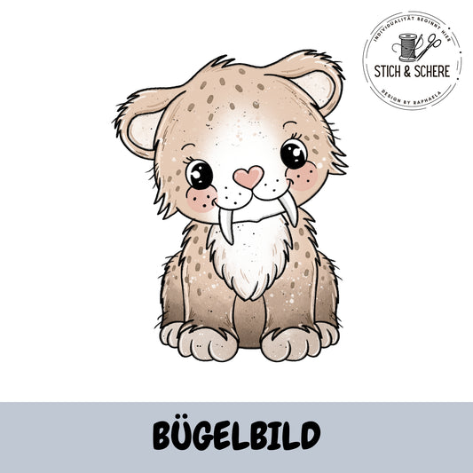 Mockup: Bügelbild „Säbeline der Säbelzahntiger“ – sitzende Säbelzahnkatze in Beige/Braun mit rosa Herz-Nase und großen Augen; oben rechts Logo „Stich & Schere“, unten graue Leiste mit Schrift „BÜGELBILD“.