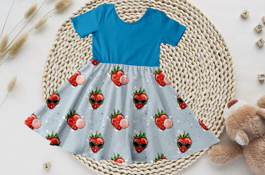 Kinder-Drehkleid mit azurblauem Bio-Jersey-Oberteil und buntem Erdbeerrock.