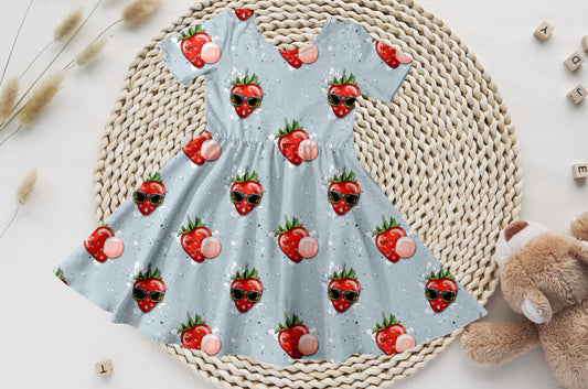 Kinder-Drehkleid mit Erdbeeren, Sonnenbrille und Kaugummi auf hellblauem Bio-Jersey.