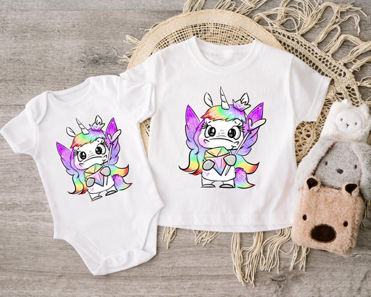 Bügelbild Einhornkönigin mit magischem Regenbogen-Motiv auf Babybody und T-Shirt.
