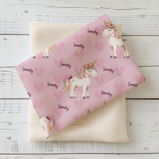 Kinderstoff mit niedlichem Einhorn-Design und Herzmotiv auf rosa Hintergrund für zauberhafte Nähprojekte.