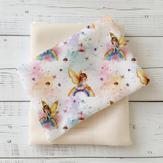 Kinderstoff "Zauberfee" in Weiß mit verträumten Feen, bunten Regenbögen, Schmetterlingen und glitzernden Details.