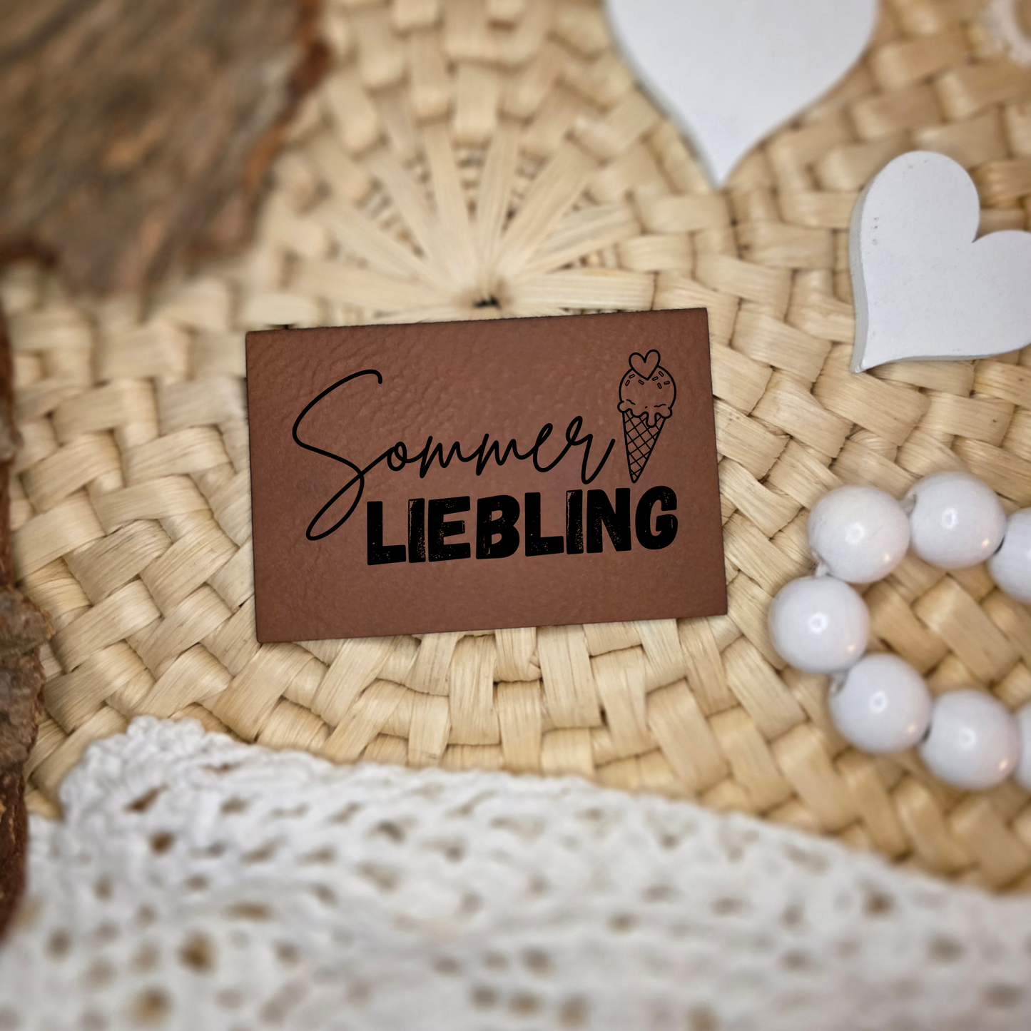 Kunstlederlabel „Sommerliebling“ in Braun mit schwarzer Gravur auf natürlicher Deko fotografiert