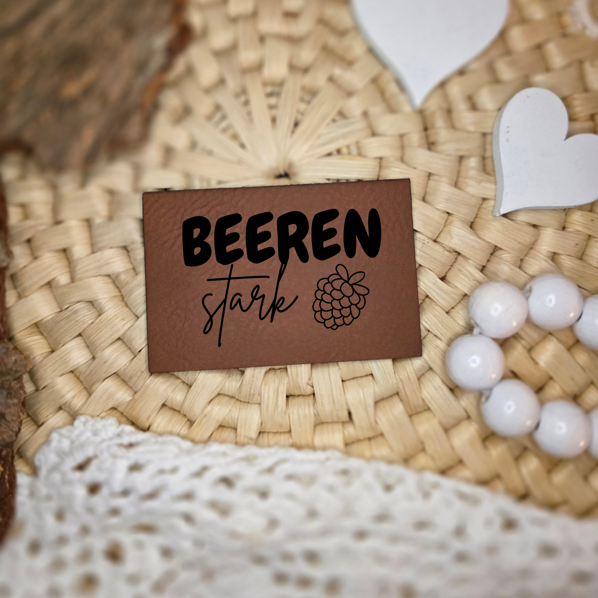 Kunstlederlabel „beerenstark“ mit Beeren-Motiv auf natürlicher Deko fotografiert