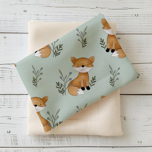 Hochwertiger Kinderstoff "Oscar der Fuchs" mit niedlichen Fuchsmotiven auf sanftem Grün – ideal für Baby- & Kinderkleidung. 