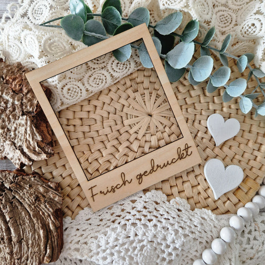 Polaroidrahmen aus Holz mit Gravur „Frisch gedruckt“ – stilvolles Flatlay-Accessoire für DIY-Projekte, Druckdesigns & Produktneuheiten.