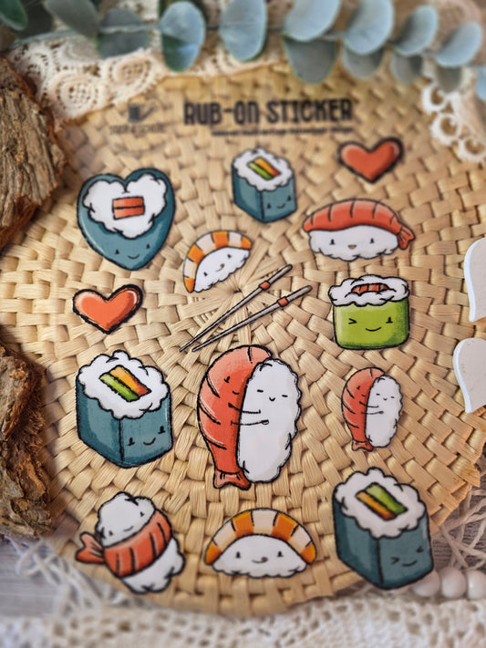 Nahaufnahme der Rub-On-Sticker „Sushilein“ – Sushi-Röllchen, Nigiri und Herzmotive auf UV-DTF-Transferfolie.