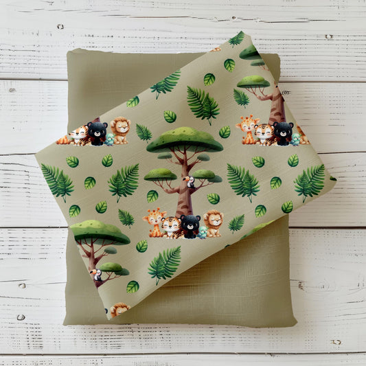 Hochwertiger Jersey-Stoff mit süßen Safari-Tieren wie Löwe, Tiger, Affe und Giraffe auf grünem Hintergrund – ideal für Kinderkleidung. 