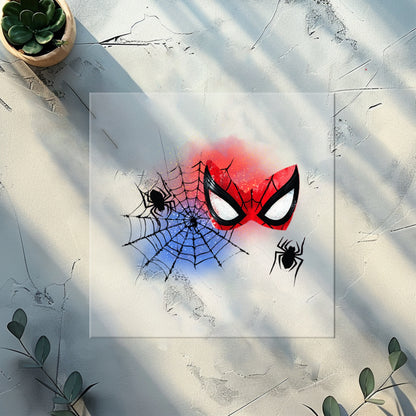 Spidermask-Bügelbild – Spinnen-Motiv mit roter Maske und Netz auf weißem Sweater.