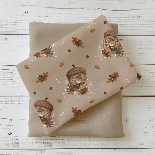 Stoff „Herbstmaus“ mit einer eingekuschelten Maus im Eichelhäuschen, umgeben von Eicheln, Herbstblättern und Zapfen, kombiniert mit einem taupefarbenen Stoff.