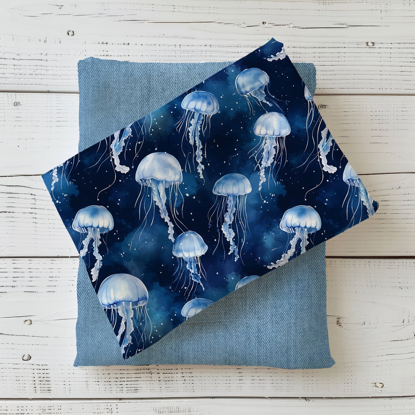 Stoff „Aquarell Quallentanz Blau“ mit hellblauen Quallen auf dunkelblauem Hintergrund, kombiniert mit einem jeansblauen Stoff.