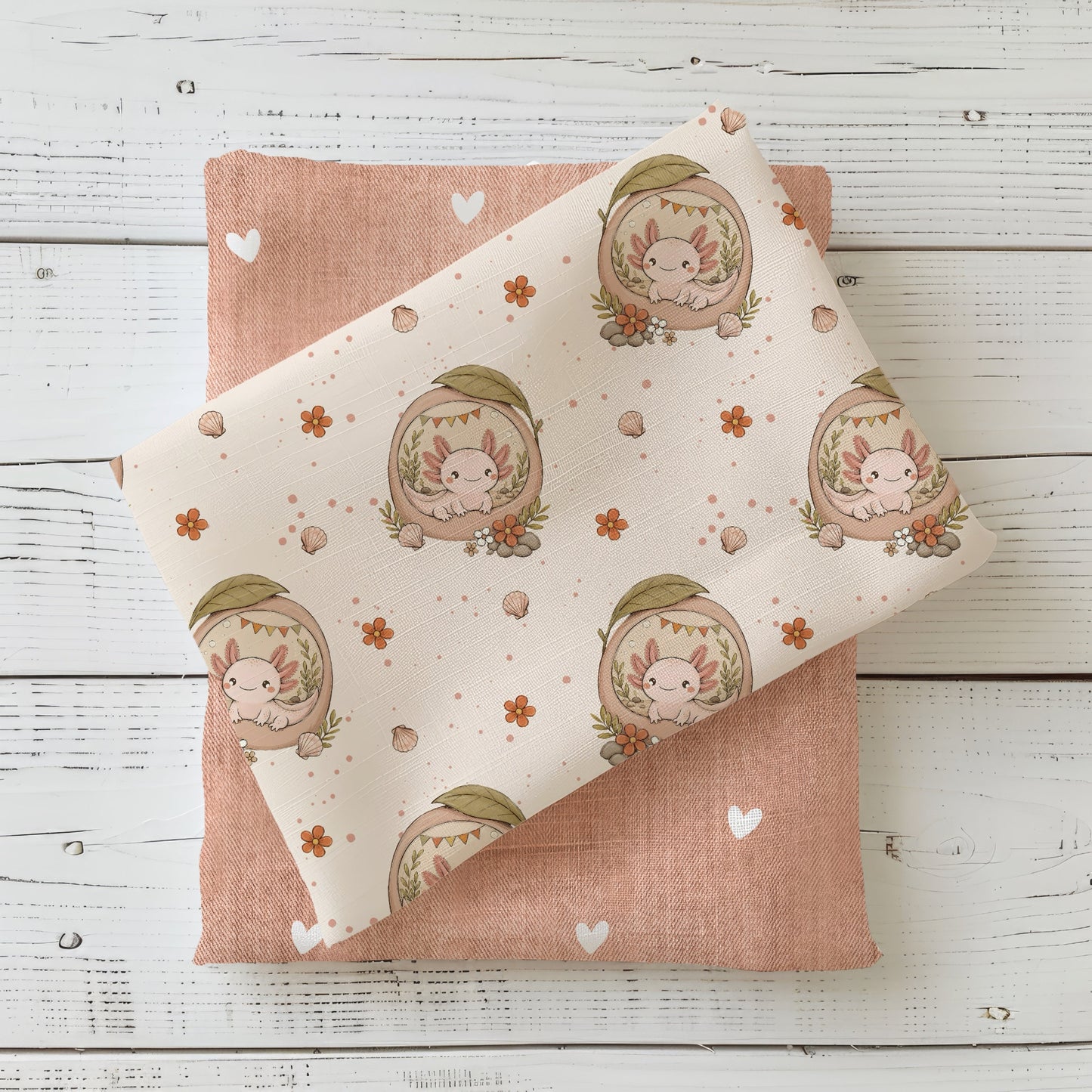 Stoffdesign Axolotlträumchen Apricot mit niedlichen Axolotl-Motiven auf hellem Hintergrund, kombiniert mit apricotfarbenem Herzchen-Kombistoff.