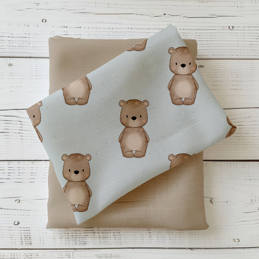 Bärchen Stoff in Nebelblau dekorativ auf hellem Holzhintergrund drapiert – neutraler Kinderstoff mit niedlichen Bären