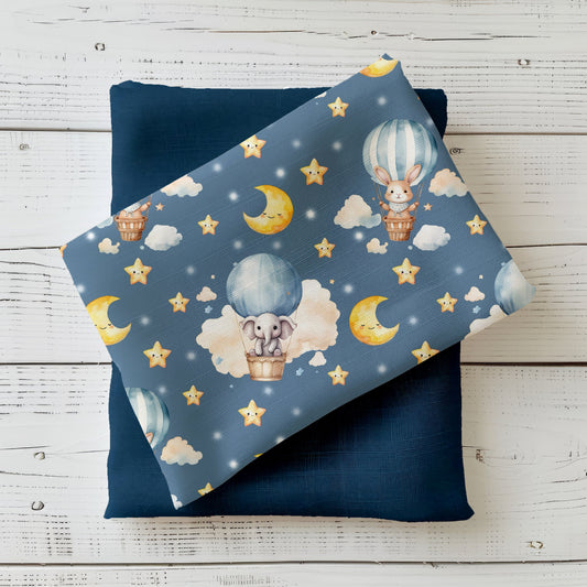 Mockup: Stoff „Ballontiere“ – Hase & Elefant im Heißluftballon, schlafende Monde, Sterne und Wolken auf nachtblauem Hintergrund; Stoffkachel diagonal auf Uni in Navy als Kombistoff.