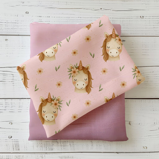 Kinderstoff mit Einhorn und Blumenkranz auf rosafarbenem Hintergrund mit kleinen Blüten