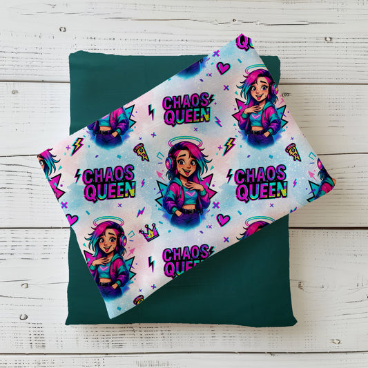 Nahtloses Stoffdesign „Chaos Queen“ mit bunter Comic‑Figur: junge Frau mit pink‑türkisfarbenem Haar, Kopfhörern, lila Bomberjacke, vor buntem Hintergrund mit Herzen, Blitzen, Pizza‑Stück und der Aufschrift „Chaos Queen“ in Neonfarben.