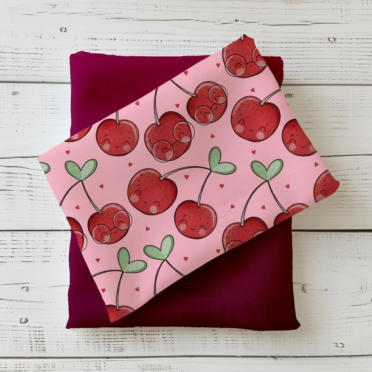 Cherrys Kirschstoff mit niedlichen roten Kirschen und kleinen Herzen auf rosa Hintergrund im Flatlay