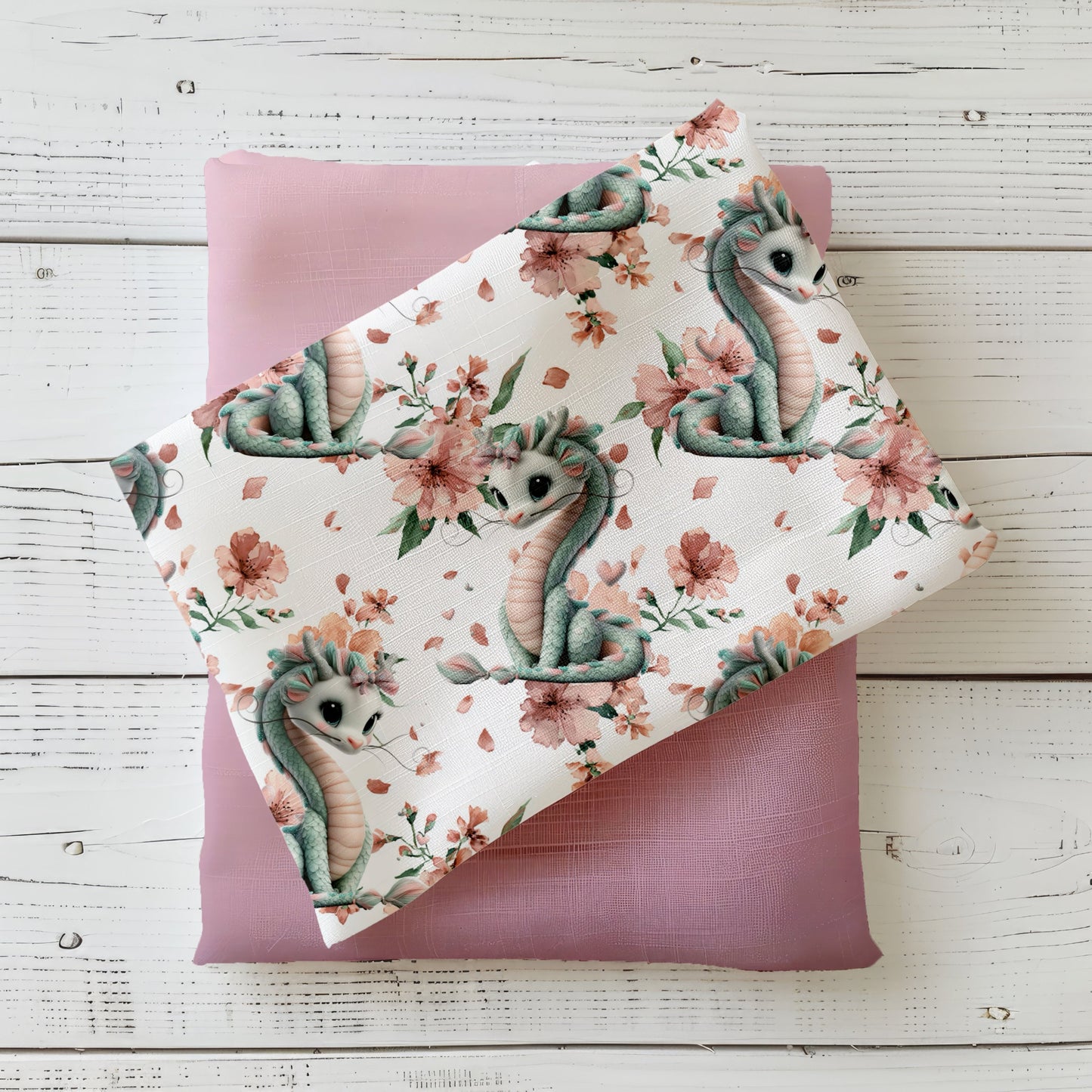 Kinderstoff mit niedlichem Drachen und Blüten in zarten Rosé- und Mintfarben auf hellem Hintergrund