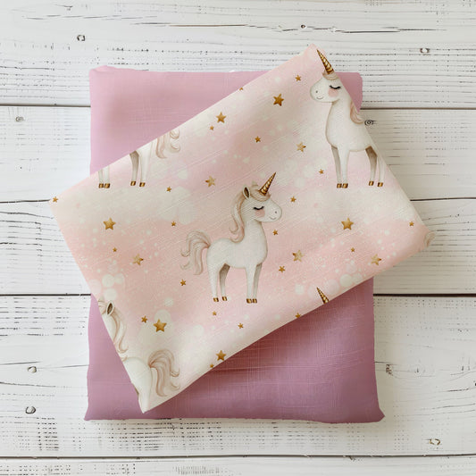 Rosa Stoff mit weißen Einhörnern und goldenen Sternen – Design „Einhornglück“ auf Produktfoto.