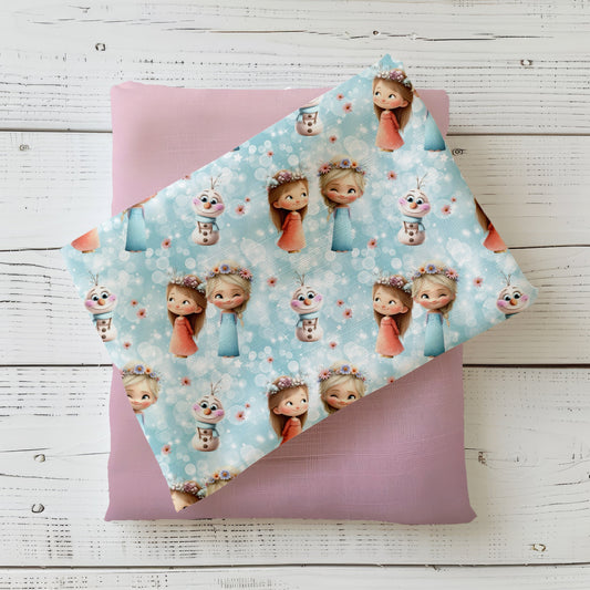 Gefalteter Stoff mit dem Stoffdesign „Eisschwestern“ mit süßen Mädchen mit Blumen-Haarschmuck und Schneemann.