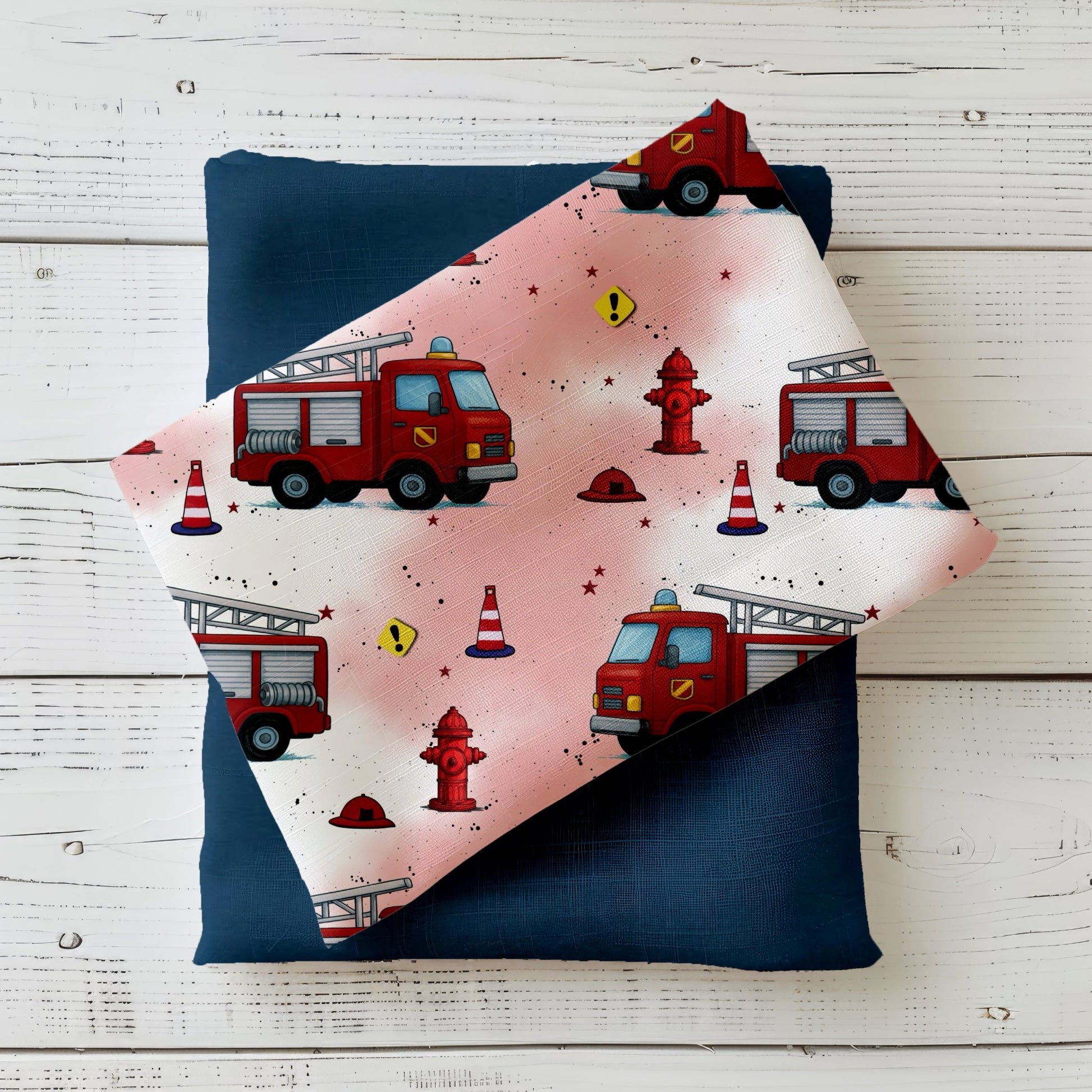 Heller rot-weißer Stoff mit roten Feuerwehrautos, Hydranten und Warnkegeln – Design „Feuerwehr Crew“ auf Produktfoto.