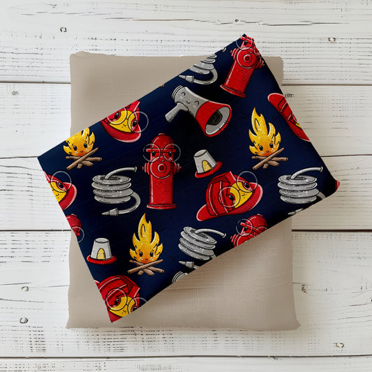 „Fire Time“ – Jersey/French Terry mit Feuerwehrmotiven: Helme, Flammen, Hydranten & Schläuche auf dunkelblauem Hintergrund.