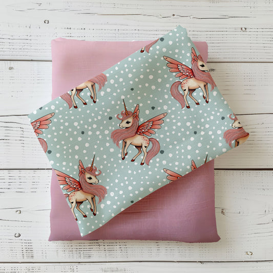 Kinderstoff mit geflügeltem Einhorn auf mintfarbenem Hintergrund mit Punkten