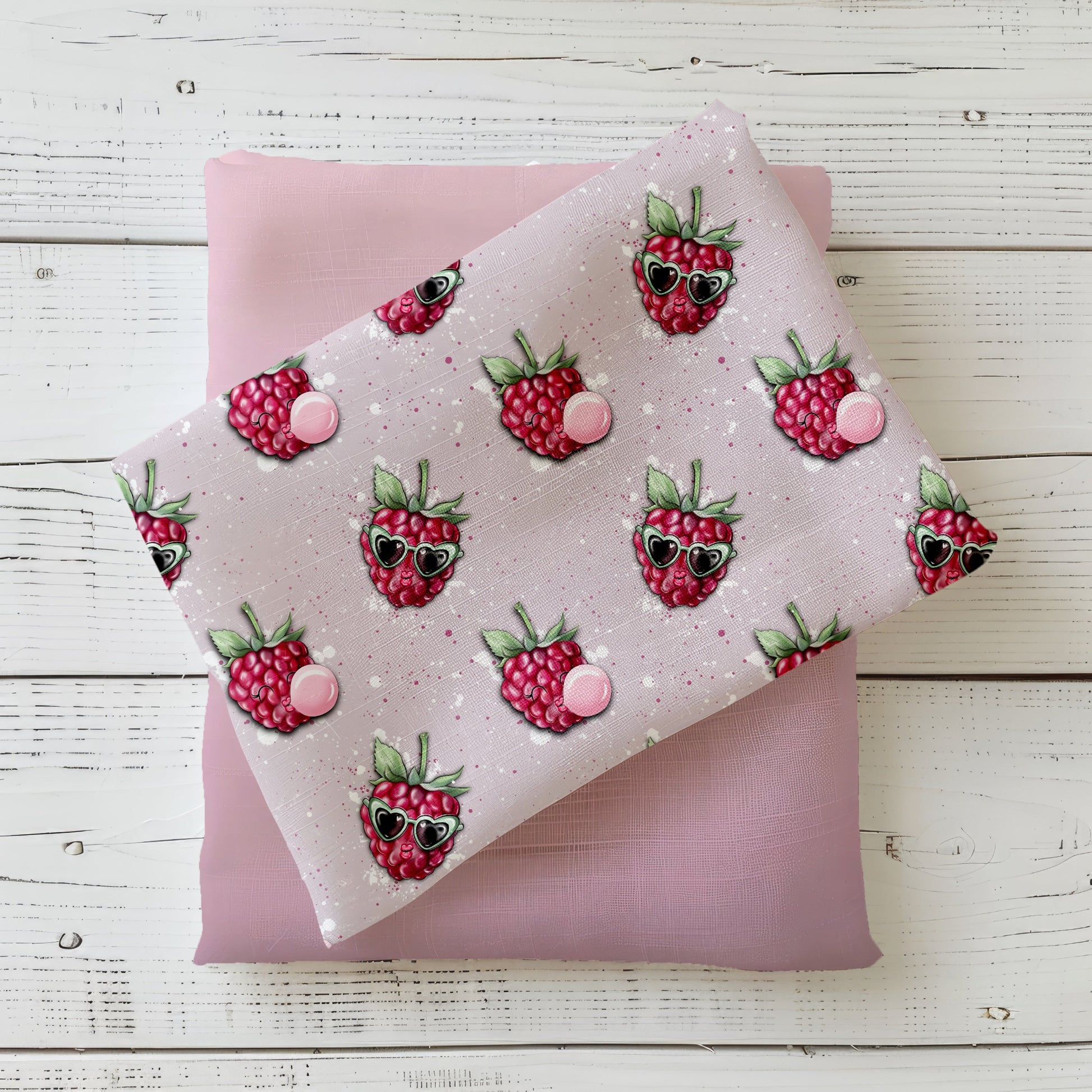 Mockup: Stoff „Freche Himbeere“ – Himbeeren mit Herz-Sonnenbrillen und Kaugummi-Bläschen auf zartrosa Sprenkel-Hintergrund; Stoffkachel diagonal auf passendem Uni in Rosa/Mauve als Kombi.