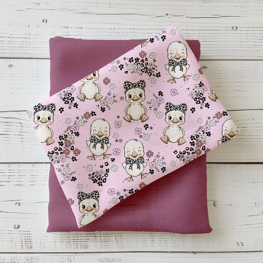 Zarter rosa Stoff mit niedlichen Baby-Gänsen mit Schleifchen und kleinen Blüten – Design „Gänsebaby“ von Katzengold-Designs.